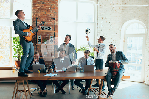 Image of Happy colleagues having fun in office while their colleagues working hard