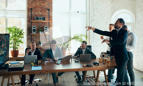 Image of Happy colleagues having fun in office while their colleagues working hard