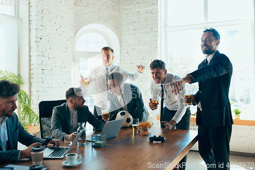 Image of Happy colleagues having fun in office while their colleagues working hard