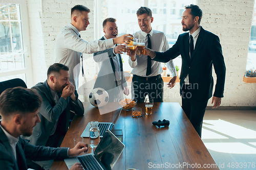 Image of Happy colleagues having fun in office while their colleagues working hard