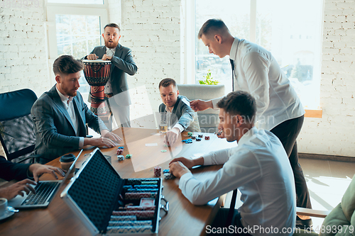 Image of Happy colleagues having fun in office while their colleagues working hard