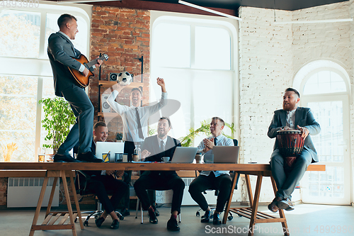 Image of Happy colleagues having fun in office while their colleagues working hard