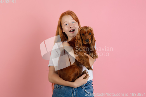 Image of Caucasian teen girl\'s portrait isolated on coral pink studio background.