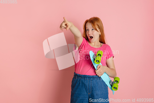 Image of Caucasian teen girl\'s portrait isolated on coral pink studio background.