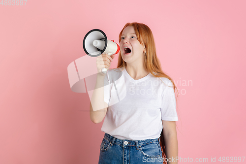 Image of Caucasian teen girl\'s portrait isolated on coral pink studio background.