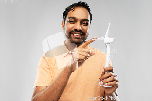 Image of smiling young man with toy wind turbine