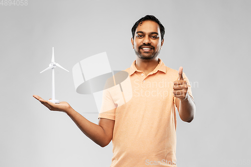 Image of indian man with toy wind turbine showing thumbs up