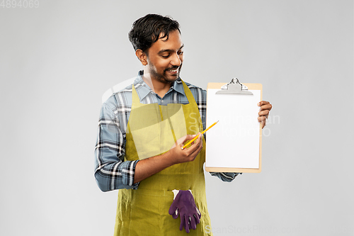 Image of happy indian gardener or farmer showing clipboard