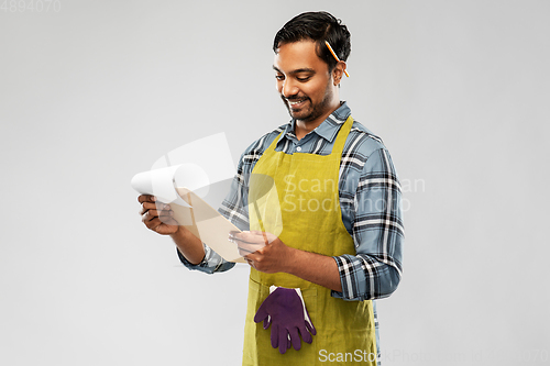 Image of happy indian gardener or farmer with clipboard