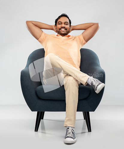 Image of happy smiling young indian man sitting in chair