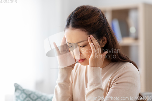 Image of sick asian woman having headache at home