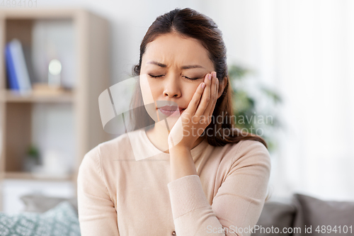 Image of unhappy woman suffering from toothache at home