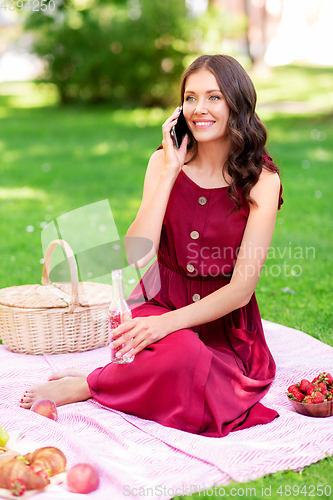 Image of woman calling on smartphone on picnic at park