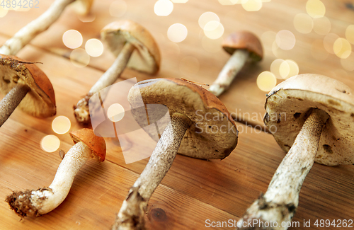 Image of brown cap boletus mushrooms on wooden background