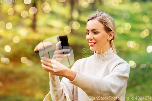 Image of woman using smartphone to identify mushroom