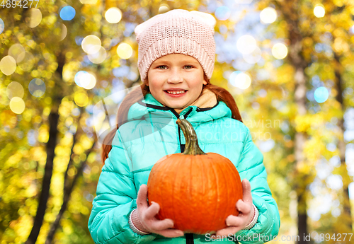 Image of happy redhead girl with pumpkin at autumn park