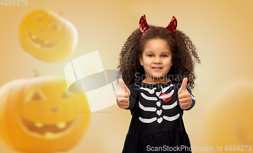 Image of girl in black dress and devil's horns on halloween