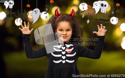 Image of girl in black dress and devil's horns on halloween