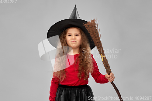 Image of girl in black witch hat with broom on halloween