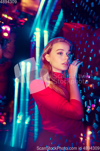 Image of Cinematic portrait of handsome young woman in neon lighted room, stylish musician
