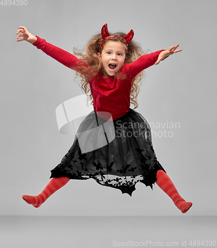 Image of girl in halloween costume of devil jumping