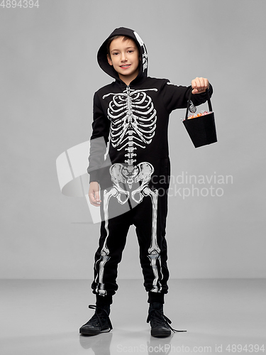 Image of boy with candies trick-or-treating on halloween