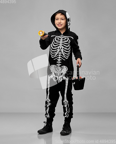 Image of boy with candies and flashlight on halloween