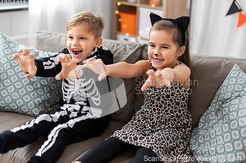 Image of kids in halloween costumes having fun at home