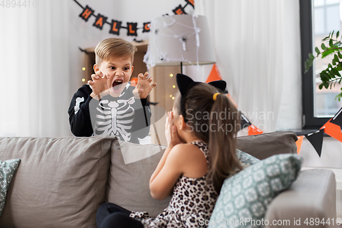 Image of kids in halloween costumes playing at home