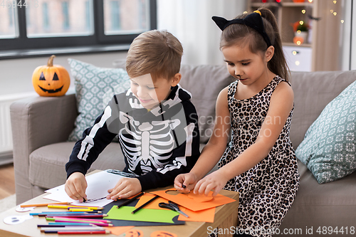 Image of kids in halloween costumes doing crafts at home