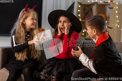 Image of kids in halloween costumes playing at home