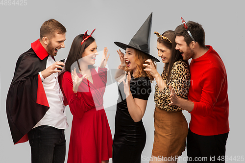 Image of friends in halloween costumes scaring each other