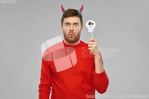 Image of man in halloween costume of devil over grey