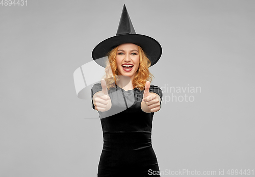 Image of happy woman in black halloween costume of witch