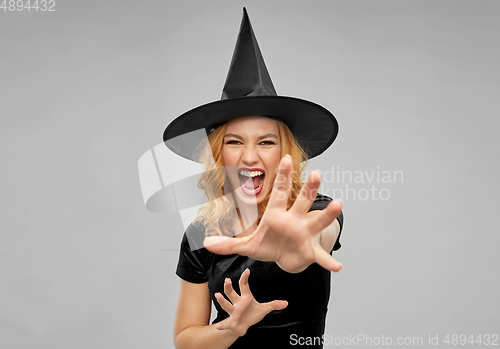 Image of scary woman in black halloween costume of witch