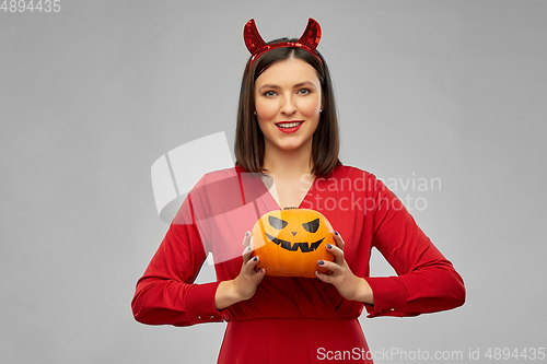 Image of woman in halloween costume of devil with pumpkin