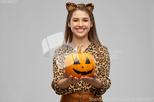 Image of woman in halloween costume of leopard with pumpkin