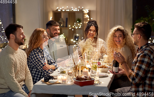 Image of happy friends with red wine at christmas party