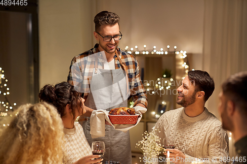 Image of happy friends having christmas dinner at home