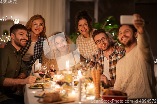 Image of friends taking selfie at christmas dinner party