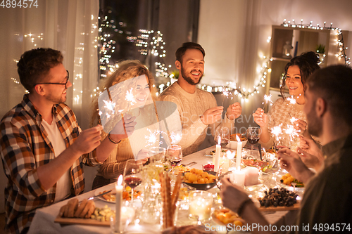 Image of happy friends having christmas dinner at home