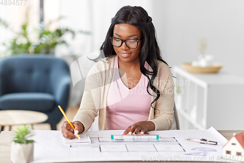 Image of female architect with house model and blueprint