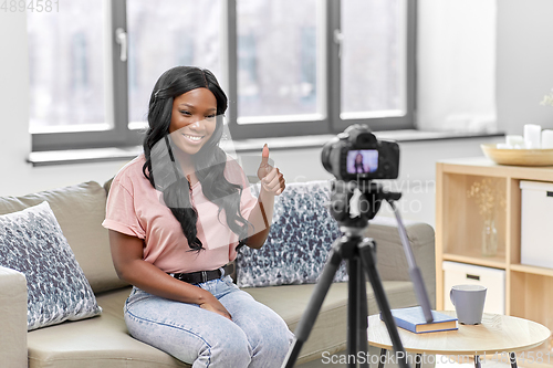 Image of female blogger with camera video blogging at home