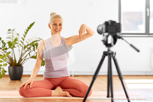 Image of woman with camera streaming for yoga blog at home