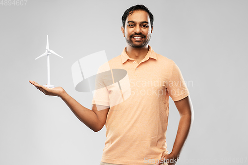 Image of smiling young man with toy wind turbine