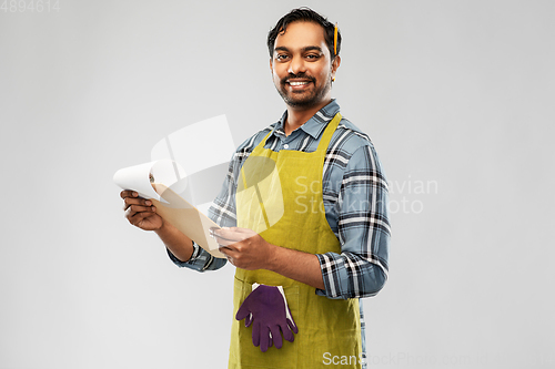 Image of happy indian gardener or farmer with clipboard