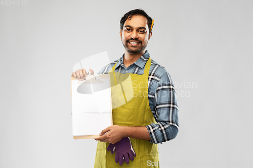 Image of happy indian gardener or farmer showing clipboard