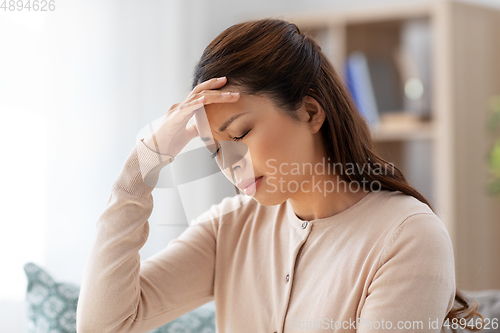 Image of sick asian woman having headache at home