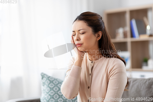 Image of unhappy woman suffering from toothache at home