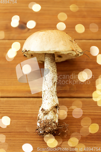 Image of brown cap boletus mushroom on wooden background